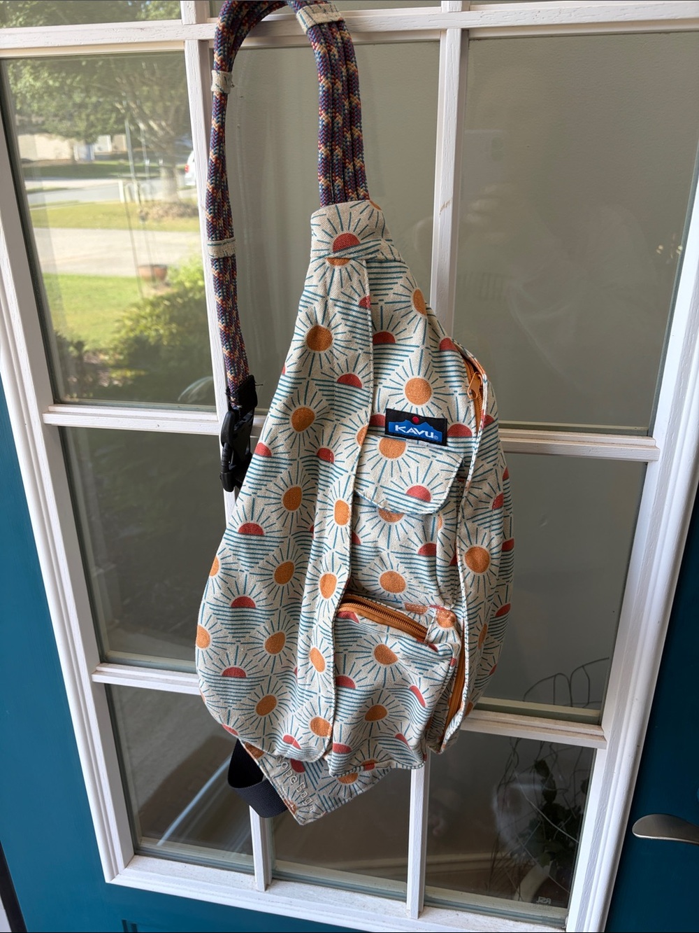 Kavu Sling Backpack- Cream with Orange and Teal Sunburst